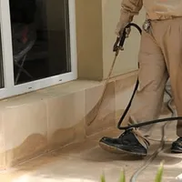 General pest control technician spraying exterior perimeter around a home in Savannah, GA
