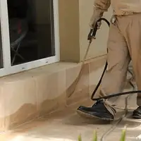 General pest control technician spraying exterior perimeter around a home in Savannah, GA