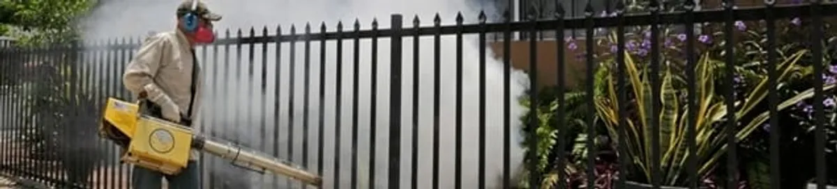 Mosquito control technician fogging a yard perimeter for mosquito reduction in Savannah, GA
